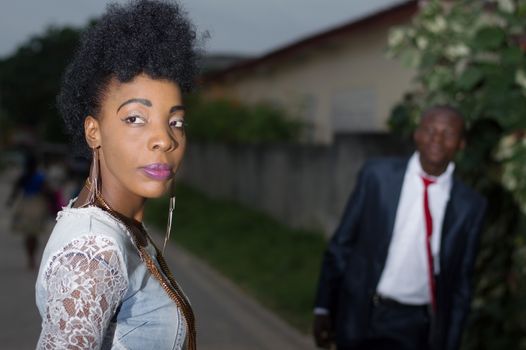 Young woman looking back and admired by her man in the street