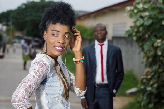 Young woman looking back and admired by her man in the street