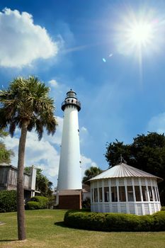 A lighthouse, palm tree, and gazebo on the coast