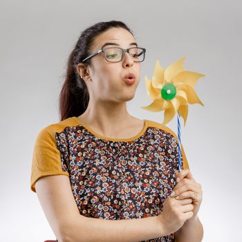 Portrait of Beautilful woman blowing a windmill