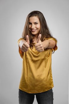 Beautiful young woman with a great smile with thumbs up