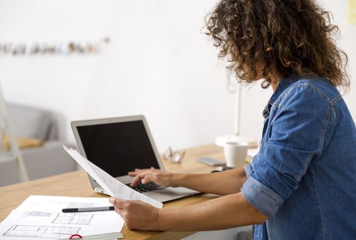 Middle age woman at the office working with a  laptop