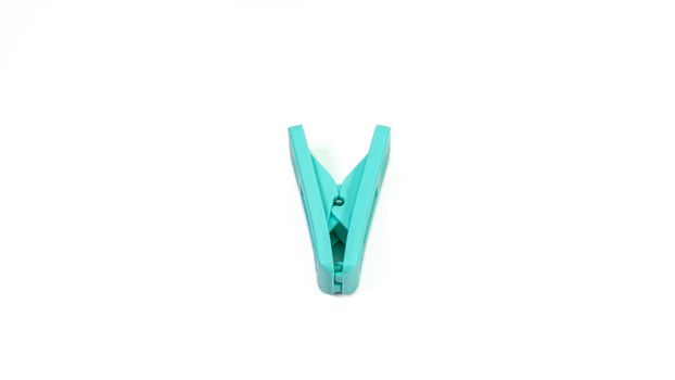 The close up of light green clothes peg on white background.
