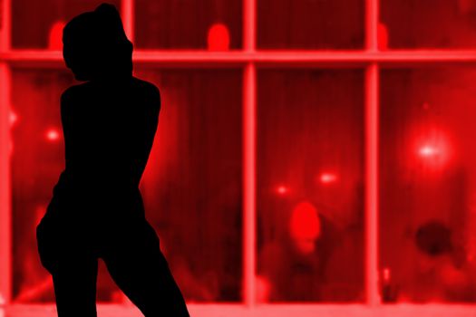 Sexy young girl silhouette standing in front of a red window hooker concept