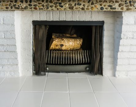 unlit fireplace with white tiling and bricks architecture and non burning wooden tree logs