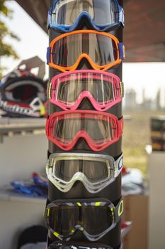 Display of colored motocross spectacles and different models at a fair stand.