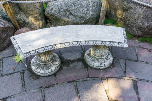 beautiful empty stone greek stylish bench in the garden