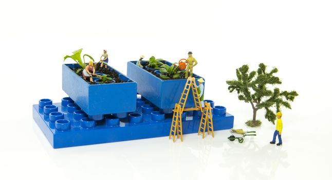 little world figures creating and busy with planting and watering the vegetable garden