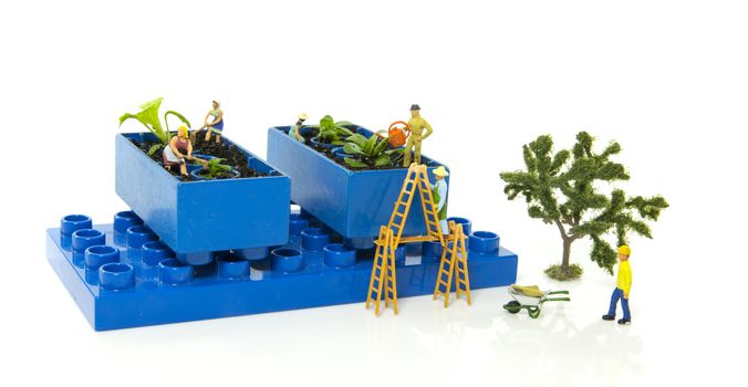 little world figures creating and busy with planting and watering the vegetable garden
