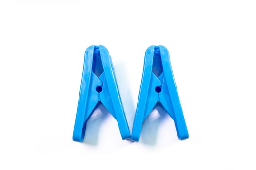 The close up of blue clothes peg on white background.