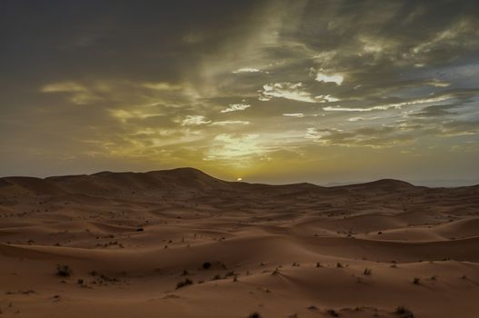 The sunset behind sand dunes in Morocco