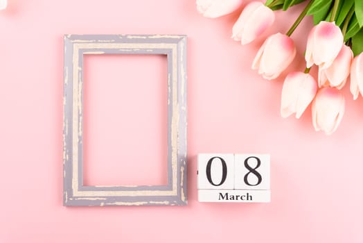 Happy Women's Day, Mother's Day concept. top view flat lay Tulip flower and photo frame on pink background, copy space for your text