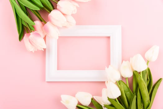 Happy Women's Day, Mother's Day concept. top view flat lay Tulip flower and photo frame on pink background, copy space for your text