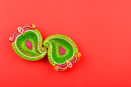 Happy Diwali Day, Flat lay top view Colorful Clay Diya lamps on red background and copy space for your text