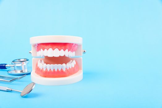 Dental Hygiene Health Concept, White tooth and Dentist tools for dental care on blue background