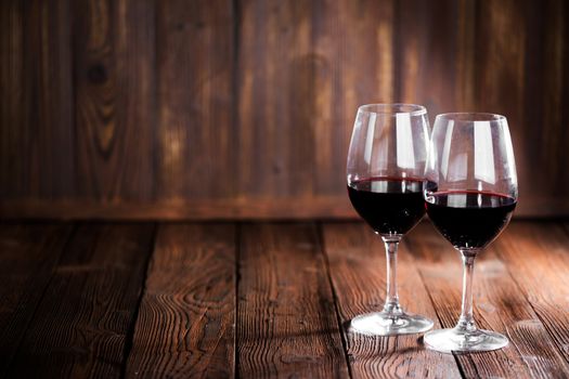 Red wine glasses on wooden background with copy space