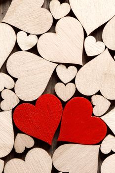 Many wooden colorless hearts background, two red special ones true love concept