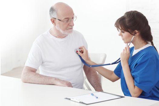 Healthcare, elderly and medical concept, doctor with stethoscope listening to senior man breath or heartbeat in hospital