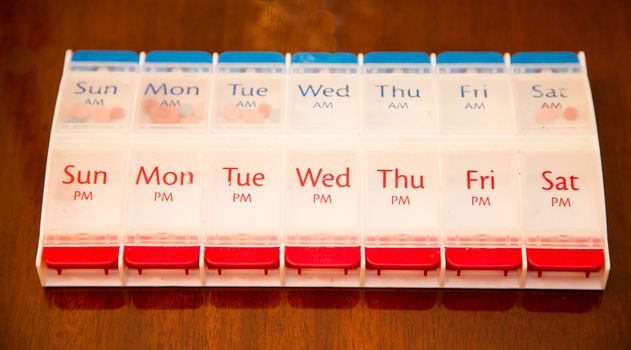 A large red, white and blue pill dispenser with room for two weeks