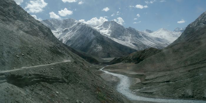 V-shaped Himalayas valley down which a river with a winding course flows. An interlocking overlapping spur hill ridges V-shaped valley that extends into a concave bend from opposite side of riverbank.