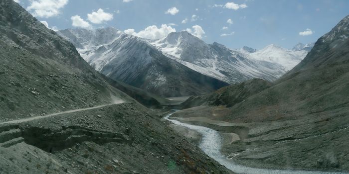 V-shaped Himalayas valley down which a river with a winding course flows. An interlocking overlapping spur hill ridges V-shaped valley that extends into a concave bend from opposite side of riverbank.