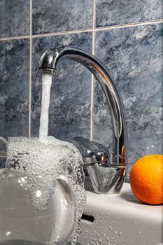 Metal water mixer and porcelain sink