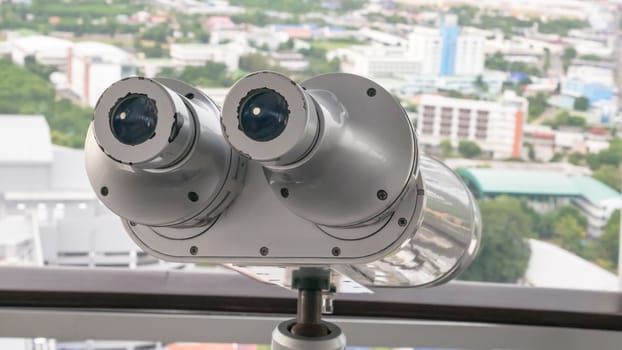 The close up of Public binocular telescope (binoscope) on top view of the Korat city town landscape in Thailand.