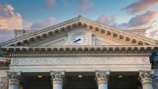 A clock and columns on an old granite courthouse