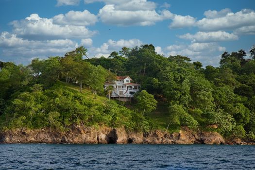 A large white villa on a hillside on a tropical island