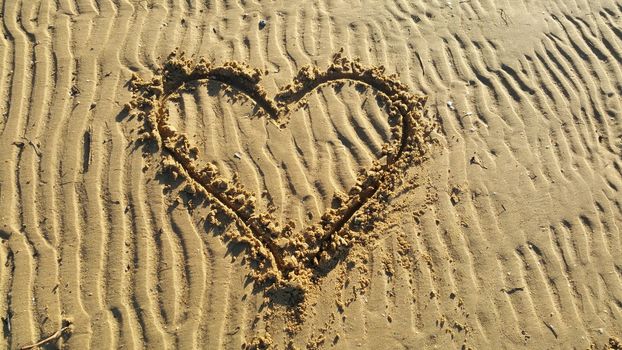 Drawing heart on the sand for Valentin day.