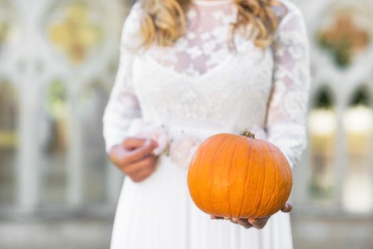 Bride holding pumpkin in her hands