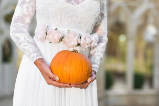 Bride holding pumpkin in her hands