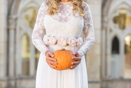 Bride holding pumpkin in her hands