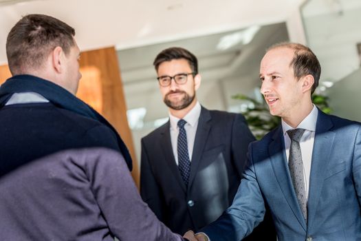 Group of confident business people greeting with a handshake at business meeting in modern office. Closing the deal agreement by shaking hands. Business and entrepreneurship success concept.