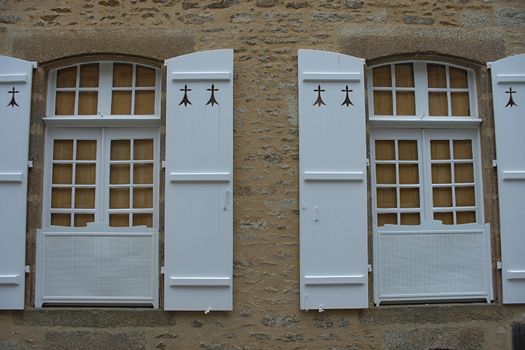 Two windows with old style blinds on stone wall