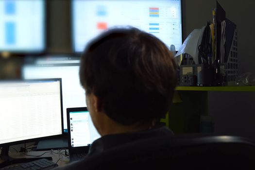 The hacker sits behind the monitor and works. The work of computer technician and programmer.