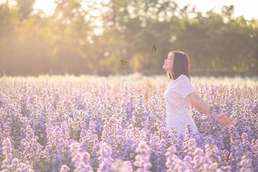 Freedom And Healthy a girl stretching her arms in the sun among the butterflies