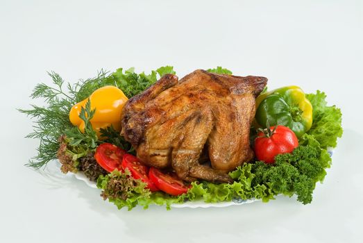 Dish with fried chicken and vegetables on a studio background