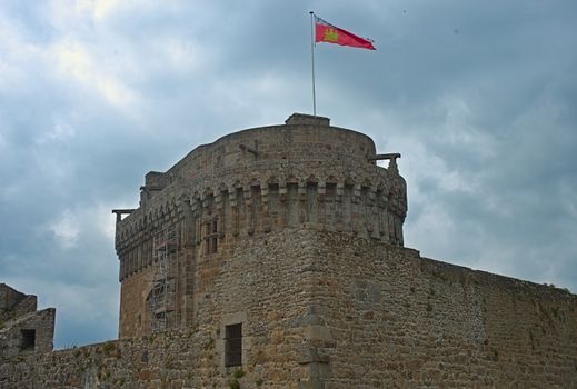 Big central stone tower with flag on top at Dinan fortress, France