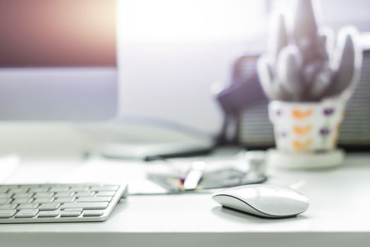 Computer desktop with white keyboard and mouse on working desk