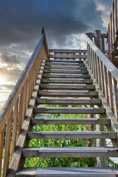 An old wooden staircase rising into the light sky