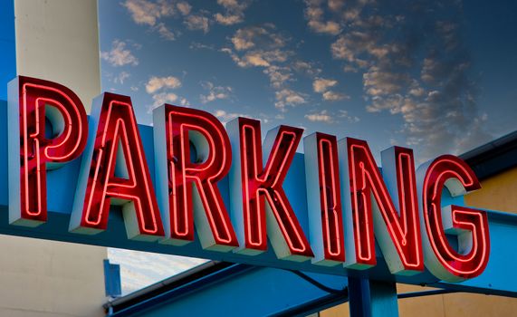 A red neon parking sign over a garage