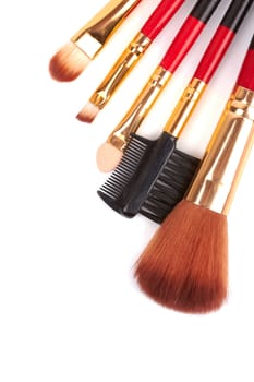 Red cosmetic brushes on a white background