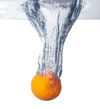 Orange falls deeply under water with a big splash. 