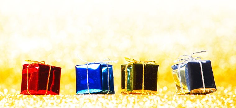 Colorful gift boxes on glitter golden background