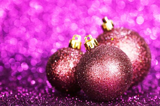 Purple christmas balls over shiny glitter background
