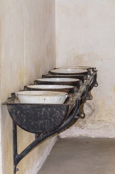 Row of old dirty sinks in an old factory
