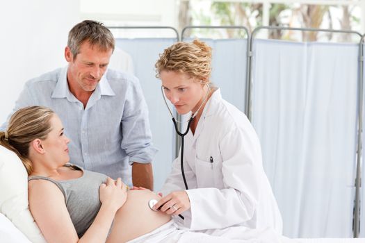 Pregnant woman with her husband listening to the nurse