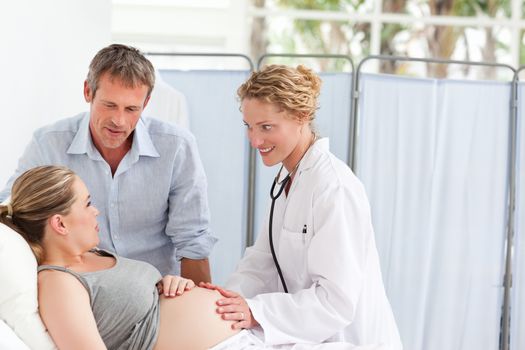 Pregnant woman with her husband listening to the nurse