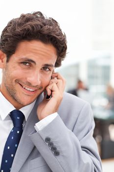 Charming businessman phoning in his office